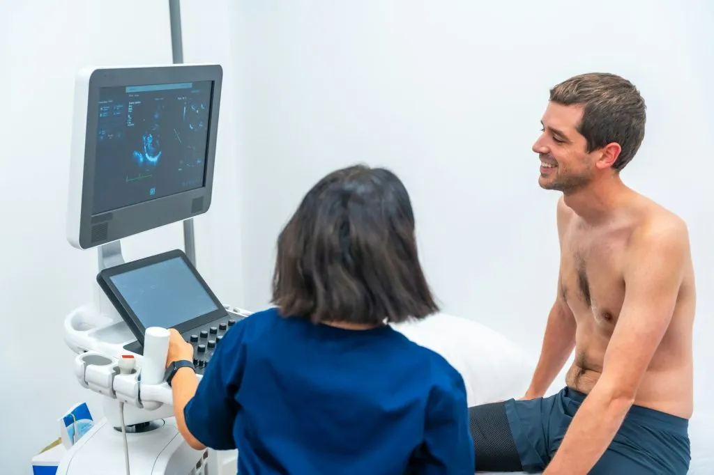 cardiologist performing an echocardiogram on a patient in the hospital